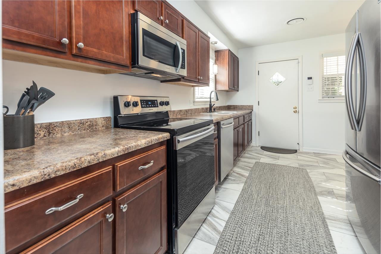 4983 Dee Road Memphis, TN 38117 - Photo 7 of 25 a kitchen with stainless steel appliances granite countertop a stove a sink and a microwave