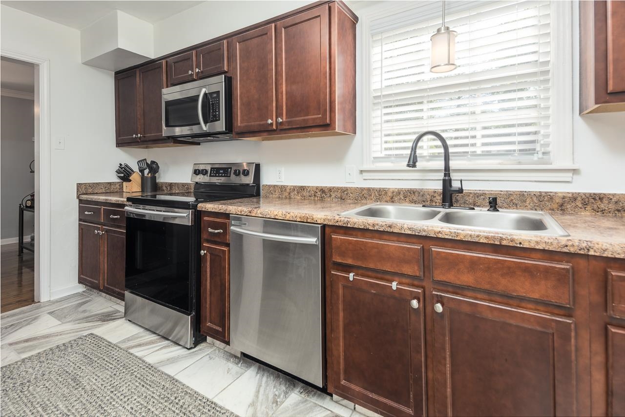 4983 Dee Road Memphis, TN 38117 - Photo 10 of 25 a kitchen with granite countertop a sink stove and microwave
