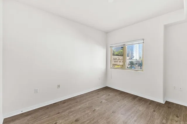 an empty room with wooden floor and window