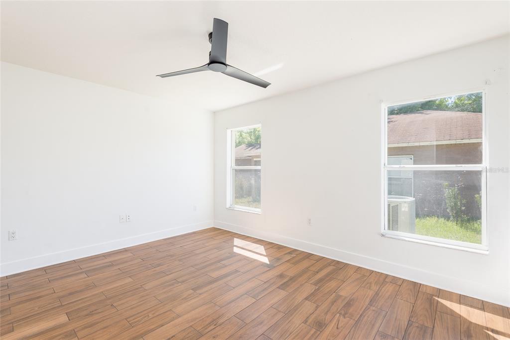 11813 Prickly Pear Way Seffner, FL 33584 - Photo 12 of 24 a view of empty room with wooden floor and fan