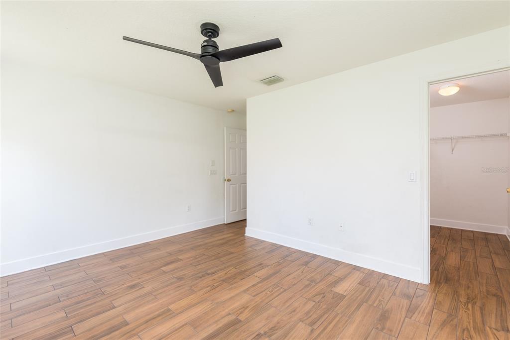 11813 Prickly Pear Way Seffner, FL 33584 - Photo 13 of 24 a view of a room with wooden floor and a ceiling fan