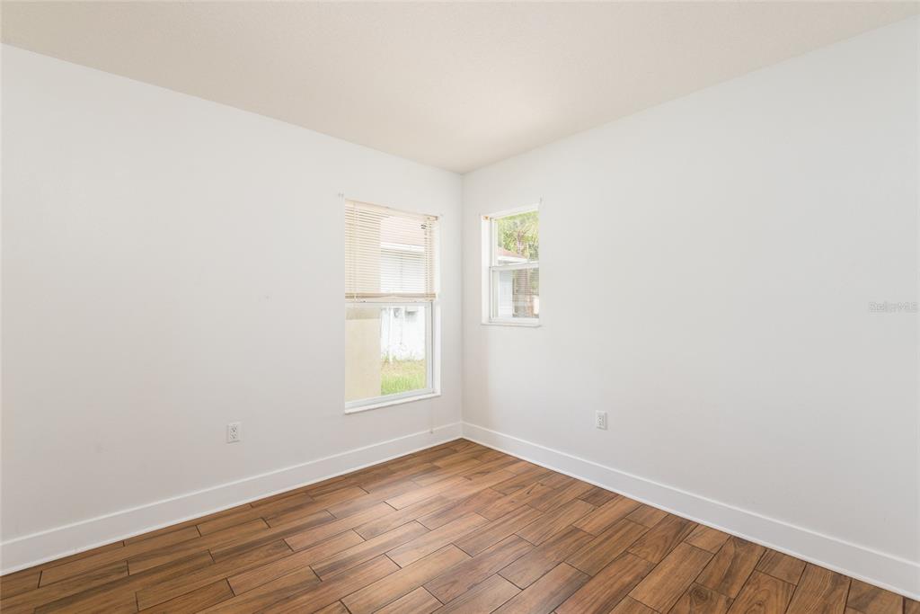 11813 Prickly Pear Way Seffner, FL 33584 - Photo 16 of 24 an empty room with wooden floor and windows