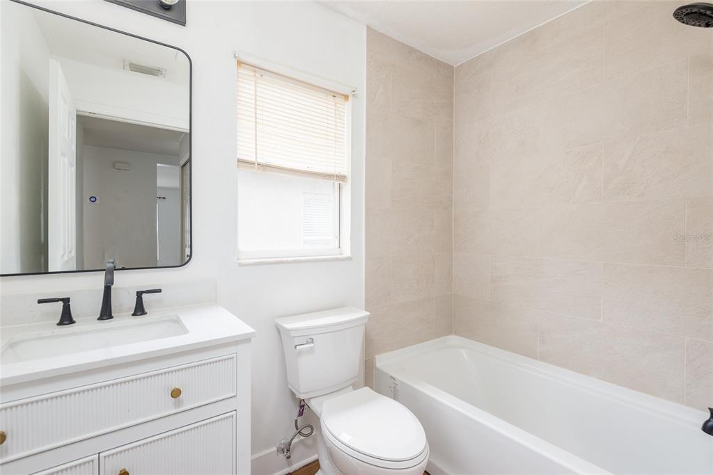 11813 Prickly Pear Way Seffner, FL 33584 - Photo 21 of 24 a bathroom with a toilet a sink a mirror and bathtub