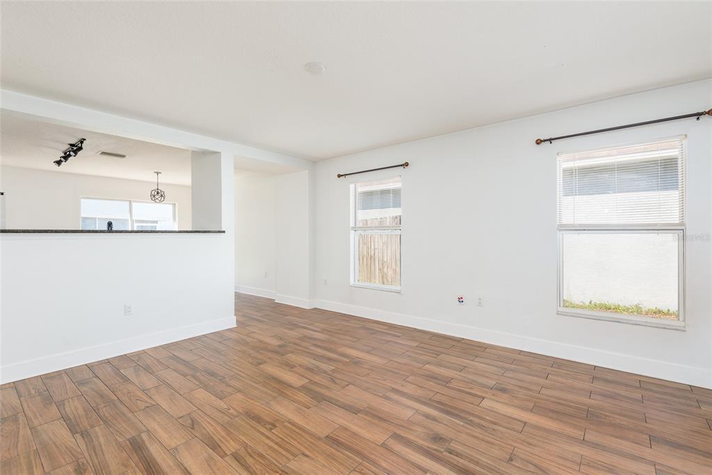 11813 Prickly Pear Way Seffner, FL 33584 - Photo 5 of 24 an empty room with wooden floor and windows
