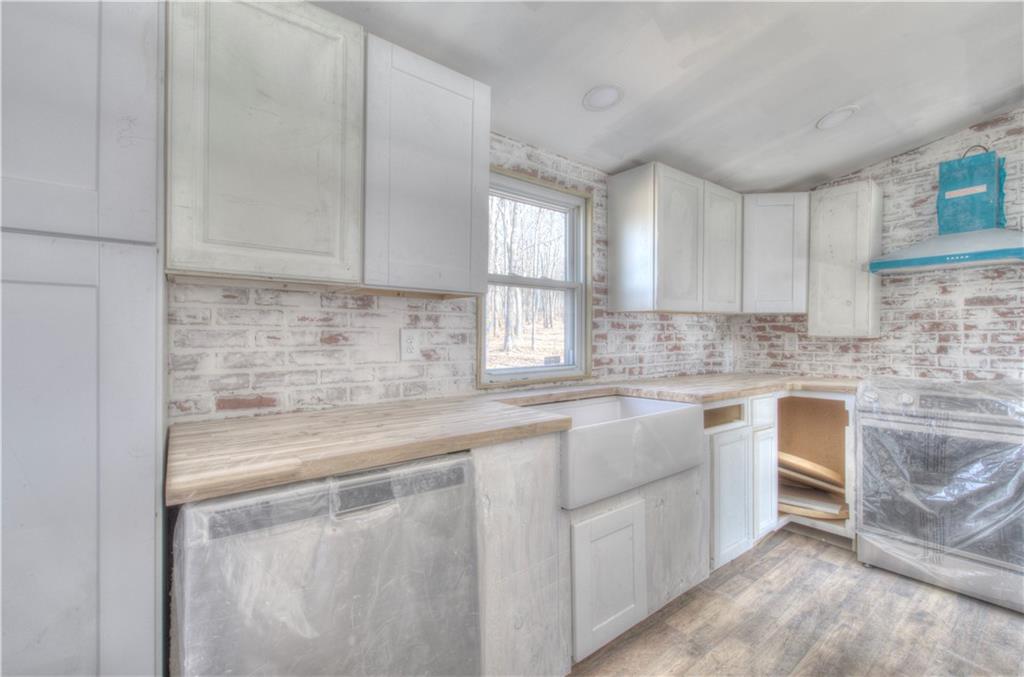 676 Flowery Branch Road Kingston, GA 30145 - Photo 30 of 96 a kitchen with white cabinets and white appliances