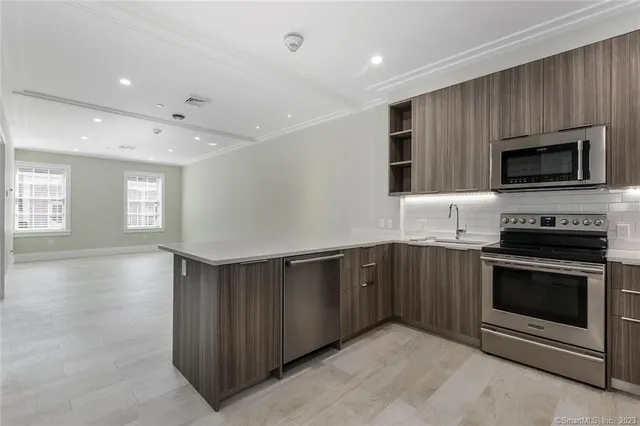 a kitchen with stainless steel appliances granite countertop a stove a microwave and a sink