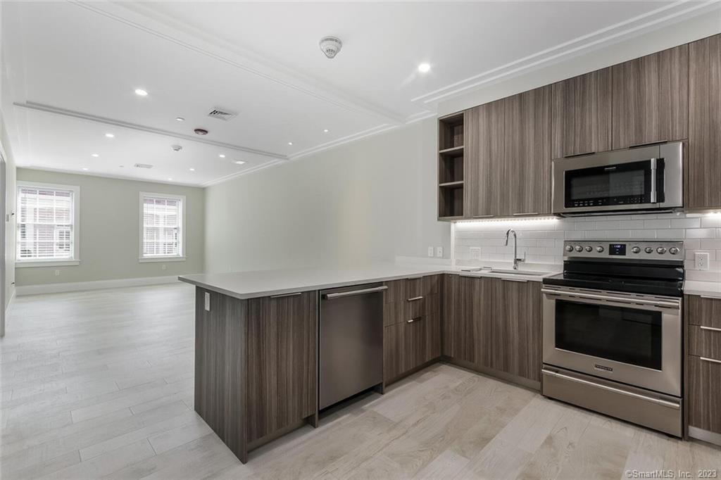 a kitchen with stainless steel appliances granite countertop a stove a microwave and a sink