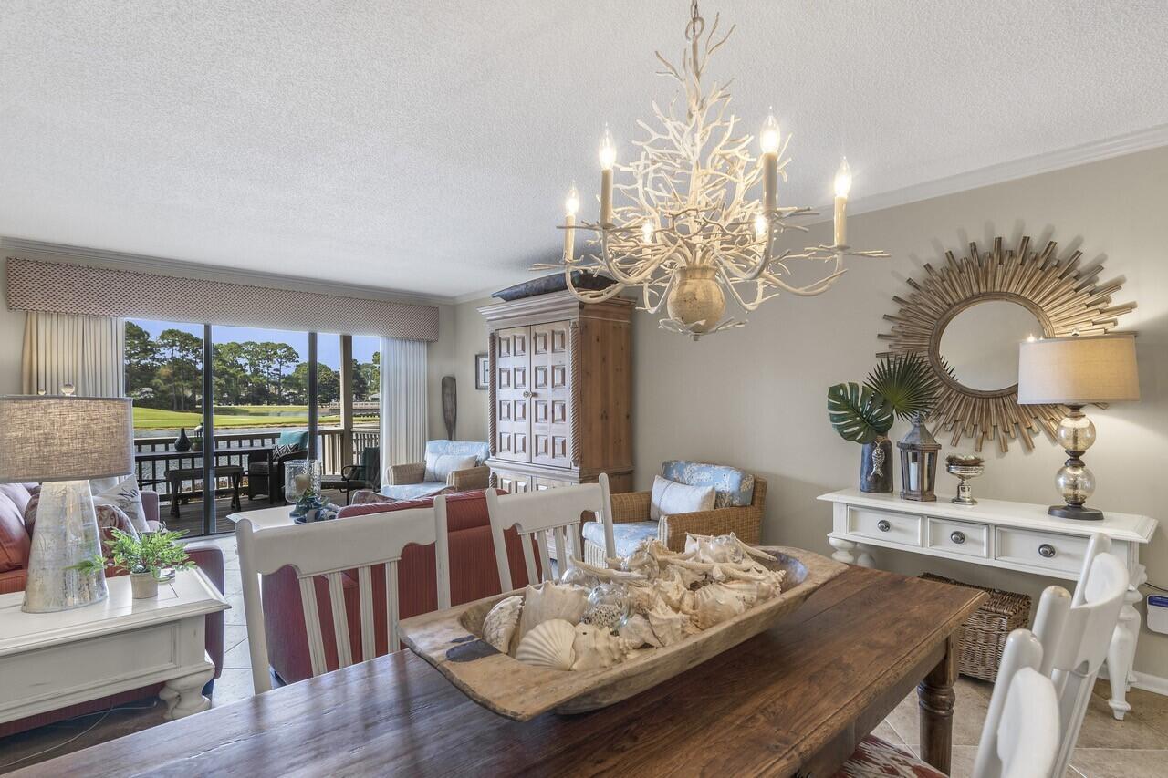 906 Harbour Point Lane, Unit 906 Miramar Beach, FL 32550 - Photo 3 of 36 a view of a dining room with furniture a chandelier and wooden floor