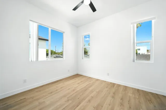 an empty room with ceiling fan and window