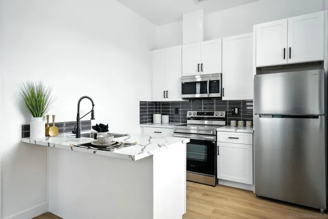 a kitchen with a refrigerator and a stove top oven