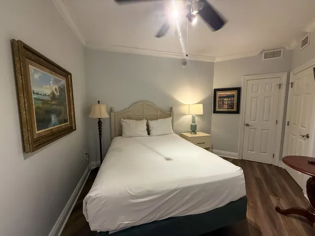 a bedroom with a bed and a painting on the wall