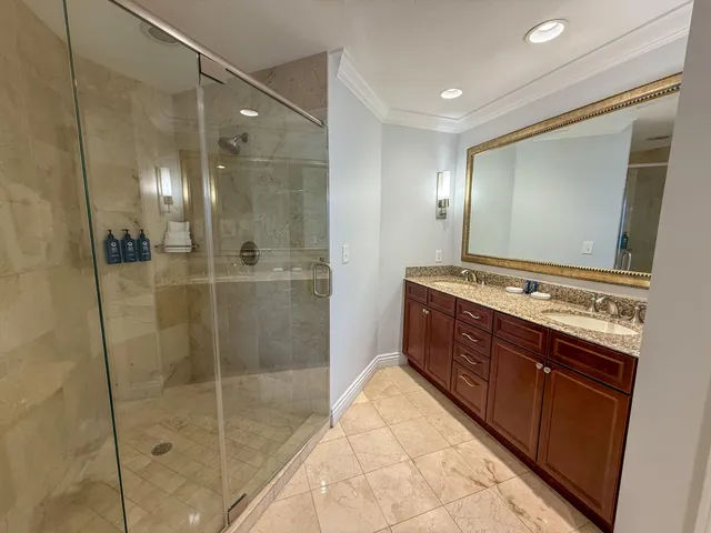 a bathroom with a glass shower door and a sink