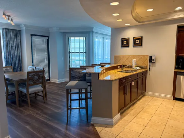 a kitchen with stainless steel appliances granite countertop a stove a sink a dining table and chairs