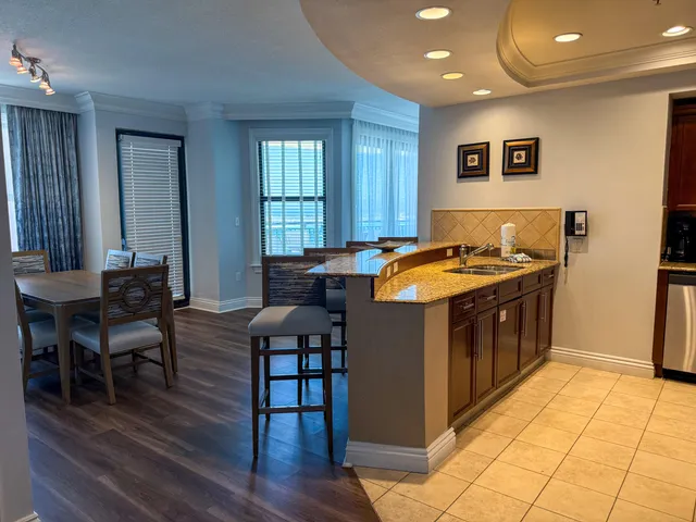 a kitchen with stainless steel appliances granite countertop a stove a sink a dining table and chairs