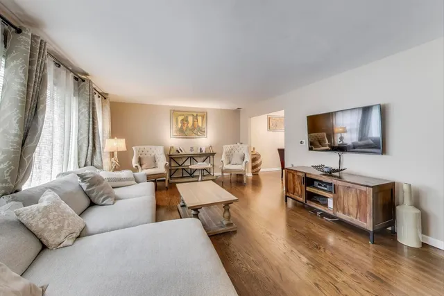 a living room with furniture flat screen tv and wooden floor