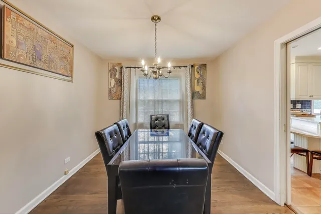 a view of a dining room with furniture wooden floor and chandelier