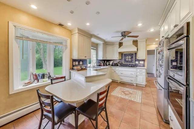 a kitchen with stainless steel appliances kitchen island granite countertop a refrigerator and cabinets