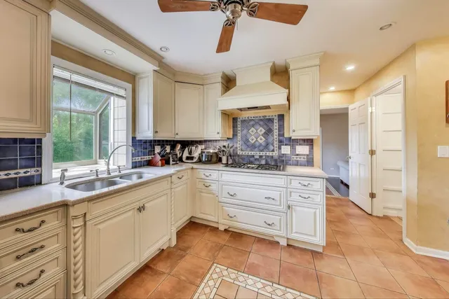a kitchen with granite countertop a sink stainless steel appliances and cabinets