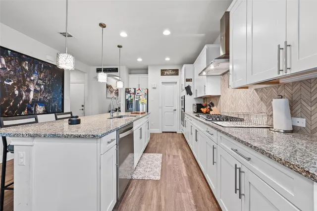 a large kitchen with granite countertop a lot of counter space and wooden floor