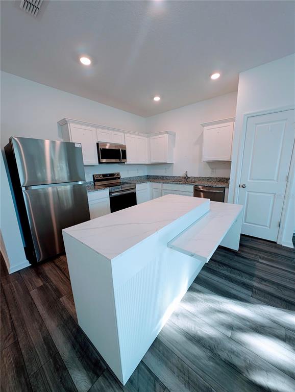 6215 Daerr Rdg Street Zephyrhills, FL 33542 - Photo 11 of 27 a large white kitchen with wooden floor