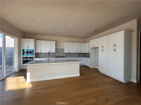a large kitchen with kitchen island a sink stainless steel appliances and cabinets