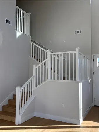 a view of staircase with railing and a rug
