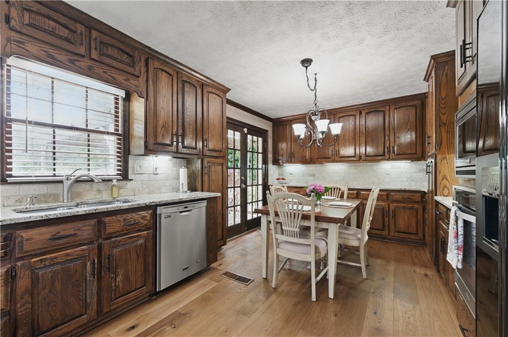 4205 Jeri Lynn Court Tucker, GA 30084 - Photo 10 of 34 a kitchen with granite countertop wooden floors cabinets a dining table and appliances