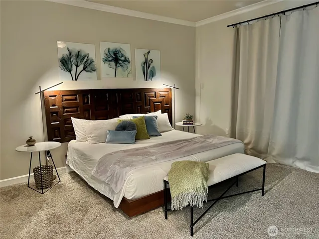 a bedroom with bed and a painting on the wall