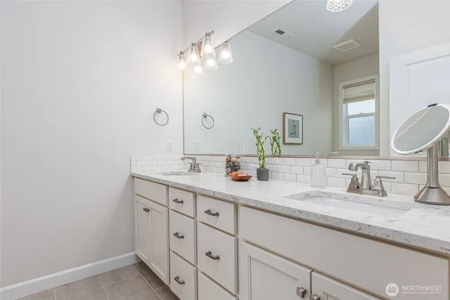 a bathroom with double sink and a mirror