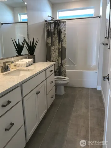 a bathroom with a granite countertop sink a toilet and shower