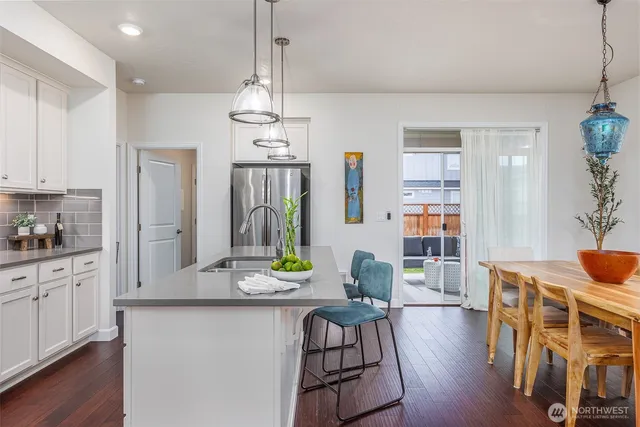 a very nice looking dining room with wooden floor and furniture