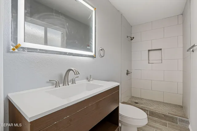 a bathroom with a sink a toilet and shower