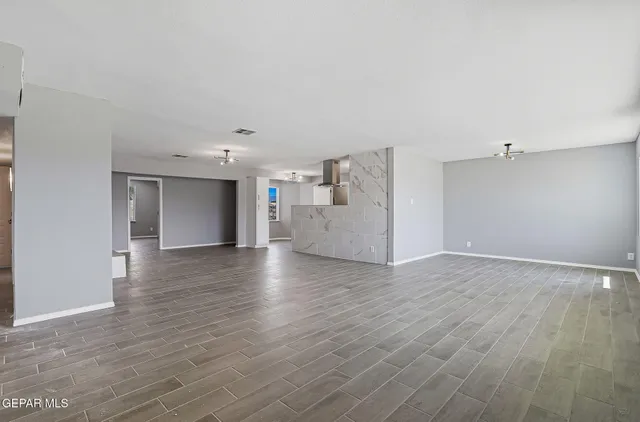 a view of empty room with wooden floor