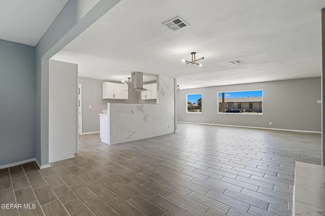 a view of a kitchen with wooden floor and a kitchen space