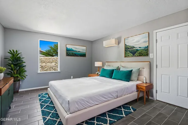 a bedroom with a large bed and a painting on the wall