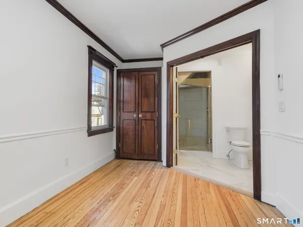 a view of a room with wooden floor and a bathroom