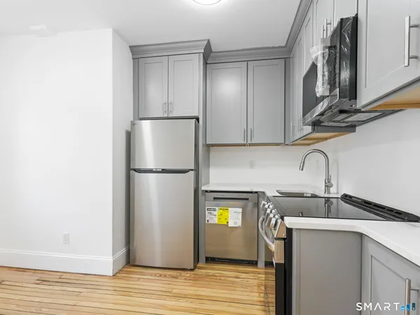 a kitchen with stainless steel appliances granite countertop a refrigerator and a sink