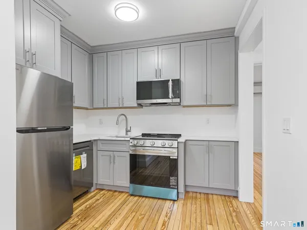 a kitchen with a refrigerator and a stove top oven
