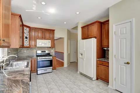 a kitchen with stainless steel appliances granite countertop a refrigerator and a sink