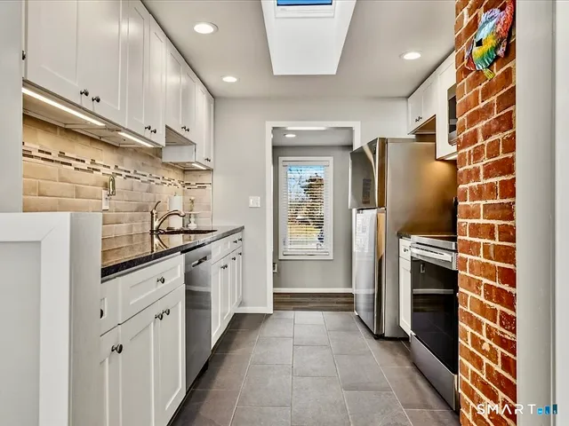 a kitchen with stainless steel appliances granite countertop a stove and a microwave