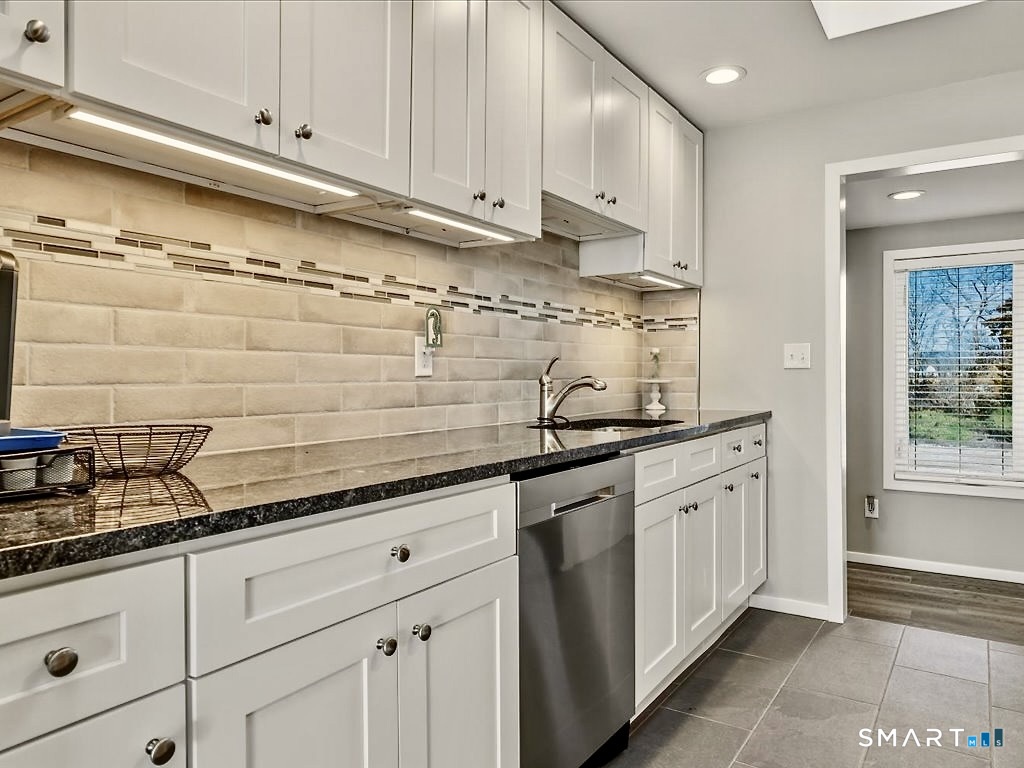 75 Shore Road Clinton, CT 06413 - Photo 20 of 40 a kitchen with granite countertop white cabinets and white appliances