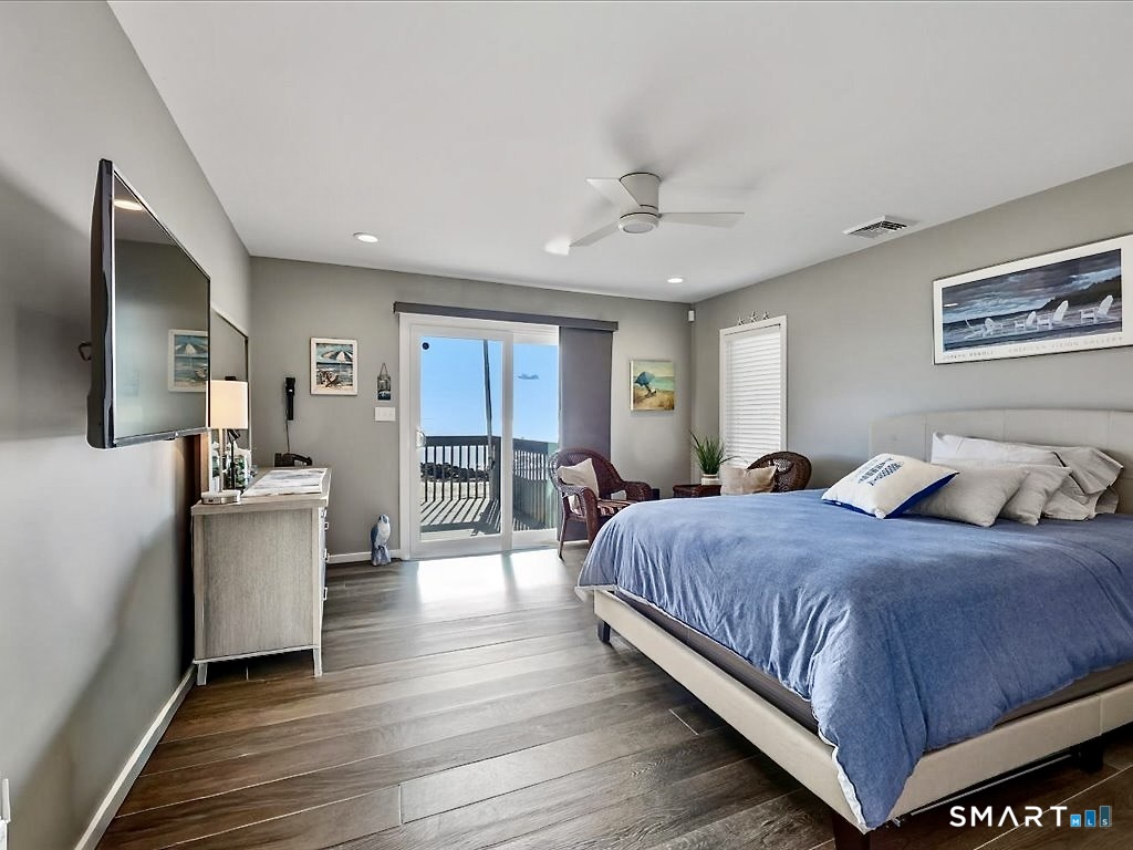 75 Shore Road Clinton, CT 06413 - Photo 21 of 40 a bedroom with a large bed a chandelier with dresser and mirror