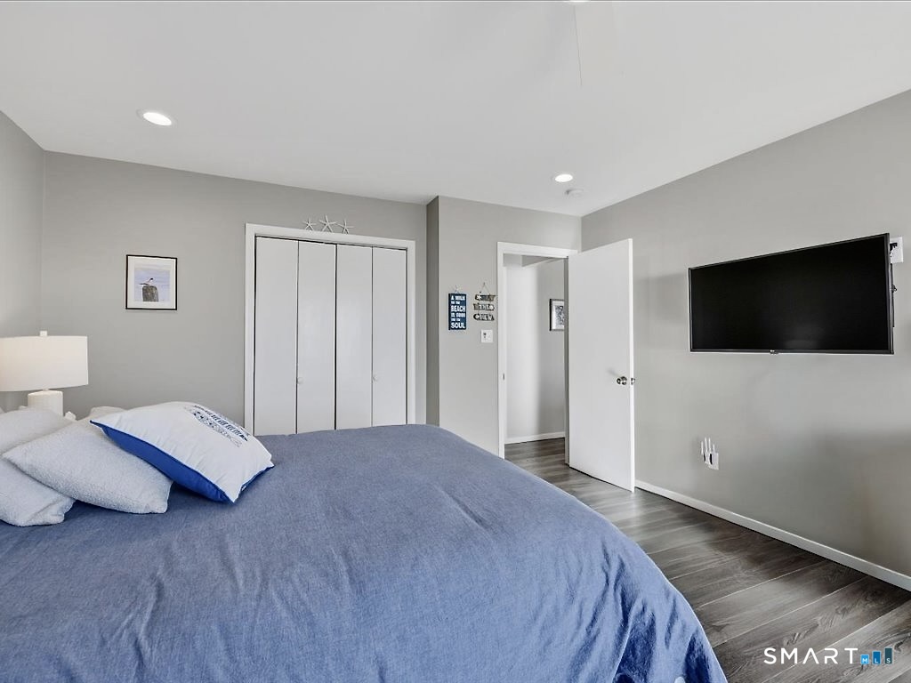 75 Shore Road Clinton, CT 06413 - Photo 24 of 40 a bedroom with a bed and a flat screen tv