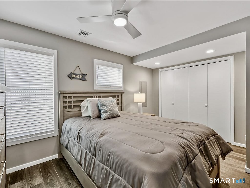 75 Shore Road Clinton, CT 06413 - Photo 25 of 40 a bedroom with a large bed and a chandelier