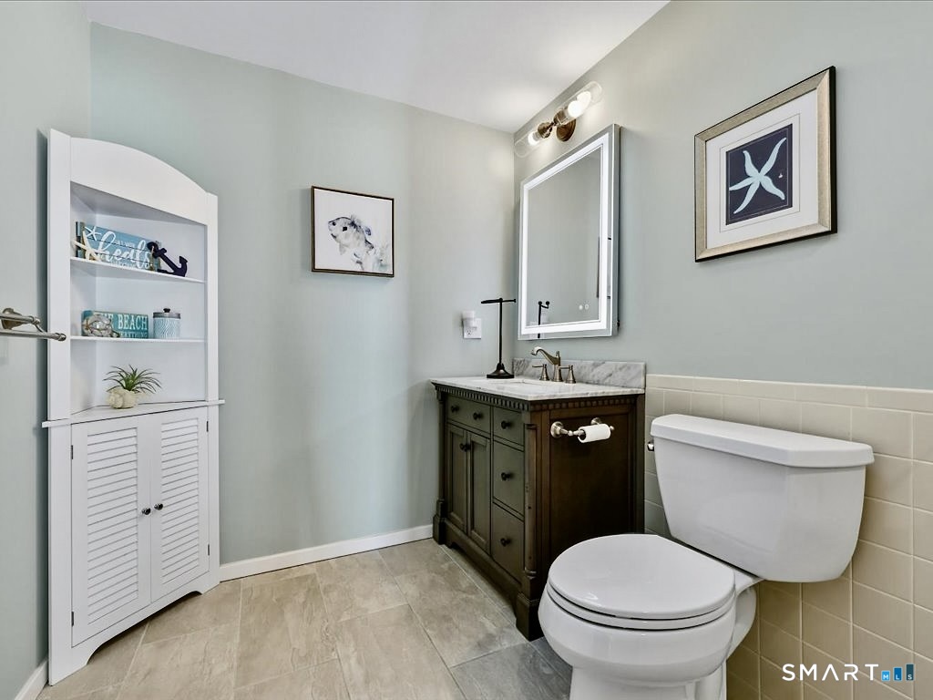 75 Shore Road Clinton, CT 06413 - Photo 29 of 40 a bathroom with a toilet sink and mirror