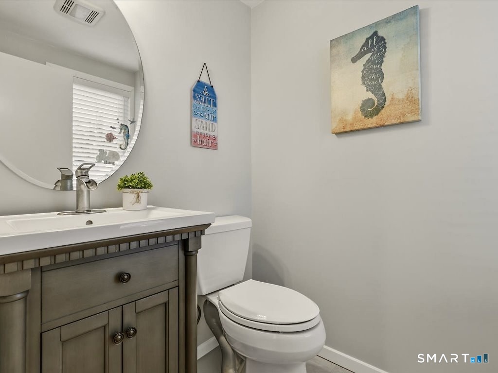 75 Shore Road Clinton, CT 06413 - Photo 32 of 40 a bathroom with a granite countertop toilet sink and mirror