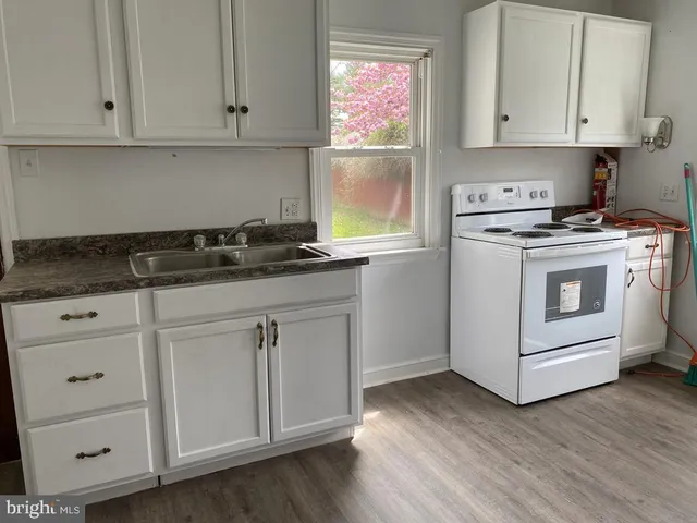a kitchen with granite countertop white cabinets and white appliances