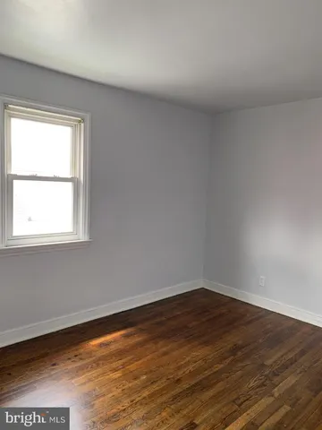 a view of a room that has wooden floor and a window