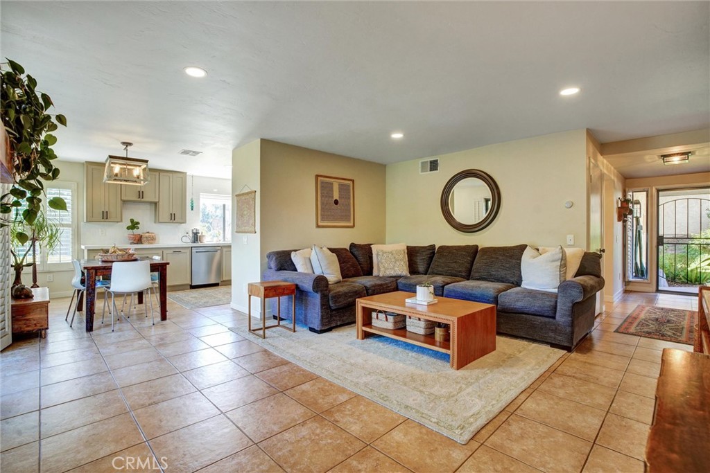 a living room with furniture a clock on wall and a window