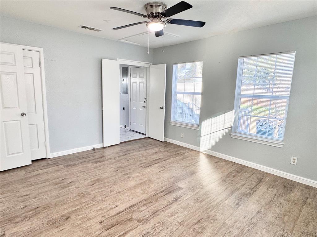 202 North Riverside Drive Fort Worth, TX 76111 - Photo 14 of 25 a view of an empty room with wooden floor and a window